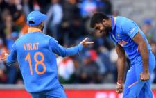 India's Vijay Shankar celebrates with India's captain Virat Kohli after the dismissal of Pakistan's Imam-ul-Haq during the 2019 Cricket World Cup group stage match between India and Pakistan at Old Trafford in Manchester, northwest England, on 16 June, 2019. Picture: AFP.