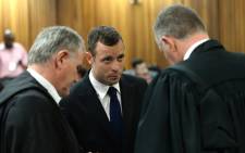 FILE: Oscar Pistorius in conversation with his legal team Barry Roux (left) and Kenny Oldwage (right) on the second day of his murder trial in the North Gauteng High Court in Pretoria on 4 March 2014. Picture: Pool.