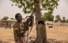 FILE: A government soldier poses with a gun on 7 March 2017 in Leer, where famine has been declared since February 2017. Picture: AFP.