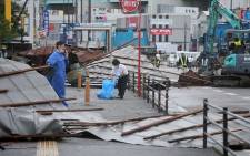 A clean-up crew works to remove roofs which were blown off into a street by strong winds brought by Typhoon Haishen in Fukuoka as the storm passes the southern Japanese island of Kyushu on 7 September 2020. Picture: AFP.