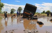 Rescue SA team members battle to free a truck used to deliver food aid to flood victims from the mud on 24 January 2015. Picture: Aletta Gardner/EWN