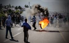 A protester swings around a burning tyre. Picture: Thomas Holder/EWN.