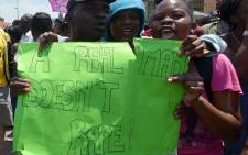 Protesters hold on 18 October, 2013 a placard reading "A Real Man Doesn't Rape!" during a demonstrating in Diepsloot, north of Johannesburg. Picture:AFP