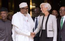 his handout photo released by the International Monetary Fund shows International Monetary Fund Managing Director Christine Lagarde (R) shaking hands with Nigerian President Muhammadu Buhari (L). 