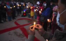 Volunteers light candles forming the shape of a red ribbon during an awareness event on the eve of the World Aids Day, in Kathmandu on 30 November 2020. Picture: AFP