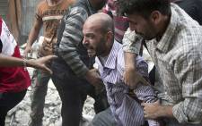 A grief-striken Syrian man is comforted by people as rescuers pull the body of his daughter from the rubble of a building. Picture: AFP.