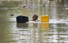 A flood-affected resident swims through floodwaters in Kalay, upper Myanmar’s Sagaing region on August 3, 2015. Relentless monsoon rains have triggered flash floods and landslides. Picture: AFP."