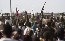 A Sudan Peoples Liberation Army (SPLA) soldier waves his AK-47 as soldiers celebrate alongside Internally Displaced People (IDP) outside the United Nations Mission in the Republic of South Sudan (UNMISS) base in Malakal after the SPLA claimed it had recaptured the town from rebels on 19 March 2014. Picture: AFP.
