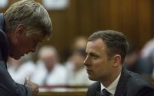 Oscar Pistorius talks to one of his lawyers Brian Webber at the High Court in Pretoria where he is appearing for sentencing procedures for shooting his girlfriend Reeva Steenkamp on 13 October 2014. Picture: Pool.