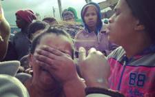A woman weeps after her shack was destroyed by fire as police carried out mass evictions in Nomzamo near Strand in Cape Town on 3 June 2014. Picture: Carmel Loggenberg/EWN.