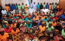 FILE: Nigeria's President Muhammadu Buhari (C) sitting among the 82 rescued Chibok girls during a reception ceremony at the Presidential Villa in Abuja, on May 7, 2017. Picture: AFP