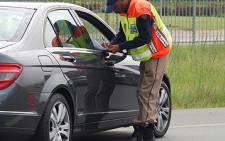 FILE: A traffic officer stops a motorist during a roadblock. Picture: EWN.