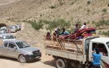 Syrian refugees ride vehicles in the Lebanese eastern border town of Arsal as they head towards the Syrian region of Qalamoun on 12 July 2017 as part of a deal that was negotiated by Syrian rebels in the camps and Lebanon's Hezbollah group. Picture: AFP.