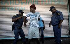 FILE: A suspected looter is detained as he emerges from of a looted foreign-owned shop in Soweto on 29 August 2018. Picture: AFP.