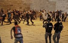 Palestinian protesters rush away amid clashes with Israeli security forces at the al-Aqsa mosque compound in Jerusalem, on 7 May 2021. Picture: Ahmad GHARABLI/AFP