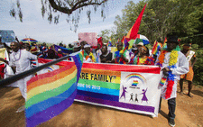 People holding rainbow flags take part in the Gay Pride parade in Entebbe on 8 August 2015. Ugandan activists gathered for a gay pride rally, celebrating one year since the overturning of a strict anti-homosexuality law, but fearing more tough legislation may be on its way. Picture: AFP
