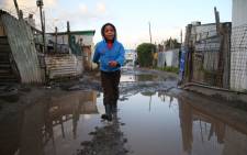 Wearing his waterproof boots a boy from Khayelitsha does not mind the puddles. Picture: Bertram Malgas
