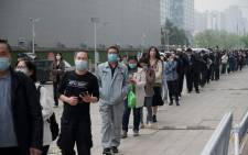 People wait in line to be tested for the COVID-19 coronavirus at a swab collection site in Beijing on 25 April 2022. Picture: Noel Celis/AFP