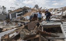 A couple react as they go through their destroyed mobile home following the passing of hurricane Laura in Lake Charles, Louisiana, on 27  August 2020. Picture: AFP