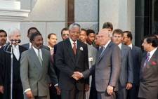 FILE: South African President Nelson Mandela (C) and former apartheid president and deputy president FW De Klerk (R) shake hands as second deputy president Thabo Mbeki (L) looks on, after the inaugural sitting of South Africa's first Parliament in Cape Town on 9 May 1994. Picture: ALEXANDER JOE/AFP
