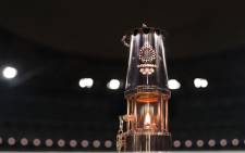 FILE: A lantern containing the Olympic flame is seen during an event to mark one year until the postponed Tokyo 2020 Olympic and Paralympic Games at the National Stadium in Tokyo on 23 July 2020. Picture: AFP