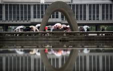 Visitors stand in front of the Hiroshima Peace Memorial park cenotaph in Naka Ward, Hiroshima Prefecture on 25 May, 2016. Picture: AFP.
