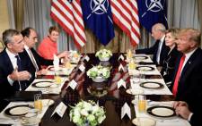 NATO Secretary General Jens Stoltenberg (L) and US President Donald Trump (R) and staff speak at a breakfast meeting at the US chief of mission's residence in Brussels on 11 July 2018, ahead of a NATO (North Atlantic Treaty Organisation) summit. Picture: AFP.