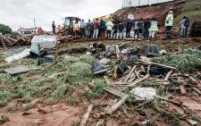 Police officers try to rescue people trapped in their homes destroyed in a mudslide following torrential downpours and flash floods, near Westcliff Secondary School in Chatsworth, south of Durban on 23 April 2019. Picture: AFP