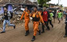 Members of an Indonesian search and rescue team carry the body of a victim, retrieved from a collapsed home, in a body bag in Rajabasa in Lampung province on 25 December 2018, three days after a tsunami - caused by activity at a volcano known as the "child" of Krakatoa - hit the west coast of Indonesia's Java island. Picture: AFP