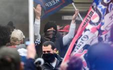 A Trump supporter gestures to other demonstrators as they try to break into the US Capitol in Washington, DC, on 6 January 2021. Donald Trump's supporters stormed a session of Congress to certify Joe Biden's election win. Picture: AFP.