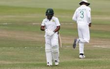 South Africa's Temba Bavuma (L) walks back to the pavilion after his dismissal by Bangladesh's Mehidy Hasan Miraz (not seen) during the second day of the first Test cricket match between South Africa and Bangladesh at the Kingsmead stadium in Durban on April 1, 2022. Picture:  Marco Longari / AFP.