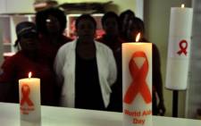 Health workers observing World AIDS Day, posing behind candles commemorating. Picture: AFP.