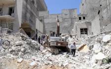 FILE: People inspect the rubble of collapsed buildings following a reported airstrike by government forces on May 24, 2015, in the rebel-held al-Sukari neighbourhood of the northern city of Aleppo in Syria. Picture: AFP.