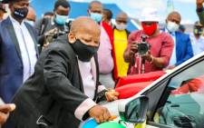 Transport Deputy Minister Dikeledi Magadzi performs the ceremonial ritual of cutting the ribbon for the 31 law enforcement vehicles handed over to the North West Province on 29 March 2021. Picture: @Dotransport/Twitter.