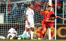Montenegro players celebrate scoring a later equalising goal against England. England's Danny Welbeck and Glenn Johnson (standing) show their disappointment. Picture: AFP