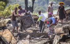 Residents of the Imizamo Yethu informal settlement in Hout Bay, Cape Town, help to clear the rubble on 28 December 2015 after a fire ripped through a section. Picture: Aletta Harrison/EWN