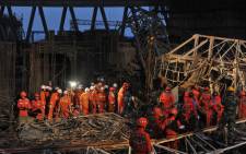 Workers search through the remains of a collapsed platform in a cooling tower at a power station at Fengcheng in China's Jiangxi province on 24 November, 2016. Picture: AFP.