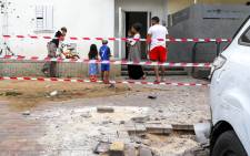 Israelis stand and inspect surrounding damages outside the cordoned area where a rocket fired by militants from the Gaza Strip fell and created a small crater in the southern Israeli town of Sderot on 9 August 2018.  Picture: AFP.