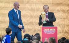 Russian President Vladimir Putin (R) holds the FIFA World Cup Trophy flanked by FIFA President Gianni Infantino (L) during the opening of the trophy tour ceremony at Luzhniki stadium in Moscow on September 9, 2017. Picture: AFP.