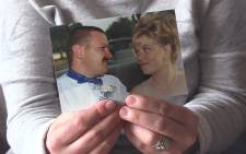 Carina Janse van Rensburg holds up a picture of her husband Roelof on their wedding day. Picture: Vumani Mkhize/EWN.