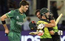 Australia's Marcus Stoinis and Matthew Wade (C) celebrate their victory as Pakistan's Shaheen Shah Afridi (L) watches at the end of the ICC men’s Twenty20 World Cup semifinal match between Australia and Pakistan at the Dubai International Cricket Stadium in Dubai on 11 November 2021. Picture: Aamir Qureshi/AFP