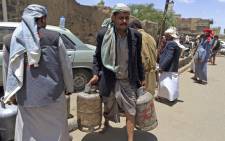 A Yemeni man carries gas cylinders after filling them up amid increasing shortages in the Yemeni capital Sanaa, on 2 September, 2018. Picture: AFP.