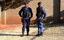 Policemen stand outside the Sophiatown Magistrates Court on 5 August 2014 ahead of the appearance of a man allegedly implicated in the shooting of Westbury toddler, Luke Tibbetts. Picture: Sapa.
