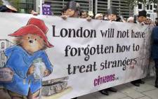 Demonstrators wearing Paddington Bear masks hold up a banner as they protest outside the Home Office in London in October 2016. Picture: AFP.