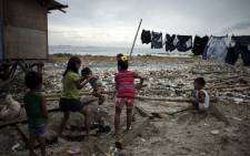 Children that live along the coast of Manila play together on 14 September 2018 as preparations get underway for Super Typhoon Mangkhut to make landfall. Picture: AFP