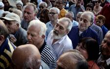 Pensioners wait to get their pensions outside a National Bank of Greece branch in central Athens on 2 July 2015, as banks only opened for pensioners to allow them to get their pensions, with a limit of €120. Picture: AFP.