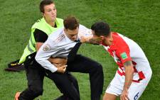 A striker is evacuated from the football pitch by security guards and Croatia's defender Dejan Lovren (R) during the Russia 2018 World Cup final football match between France and Croatia at the Luzhniki Stadium in Moscow on 15 July 2018. Picture: AFP.
