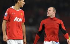 Manchester United's Wayne Rooney (R) leaves the pitch with Rio Ferdinand (L) after their win over Wigan Athletic on 20 November 2010. Picture: Andrew Yates/AFP