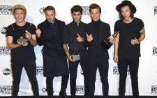 One Direction hold their three awards for Artist of the Year, Favorite Band Duo or Group and Favorite Album at the 2014 American Music Awards at the Nokia Theatre in Los Angeles on 23 November 2013. Picture: EPA