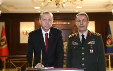 Turkish President Recep Tayyip Erdogan delivering a speech as Chief of the General Staff of the Turkish Armed Forces, as Hulusi Akar stands next to him during his condolence visit at the General Staff headquarters in Ankara. Turkish security forces on July 16, 2016 rescued the countryâs top army general in an operation in Ankara after a coup attempt, taking him to a safe location, the private CNN-Turk television reported. Picture: AFP.
